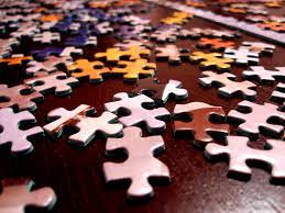 Jigsaw puzzle pieces spread out across table