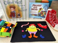 collection of books and toys about getting dressed