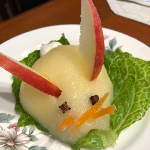 salad made of a pear half and apple slices made to look like a bunny