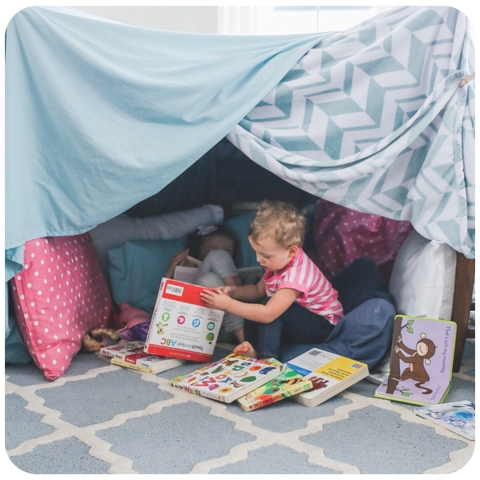 toddlers under a blanket fort