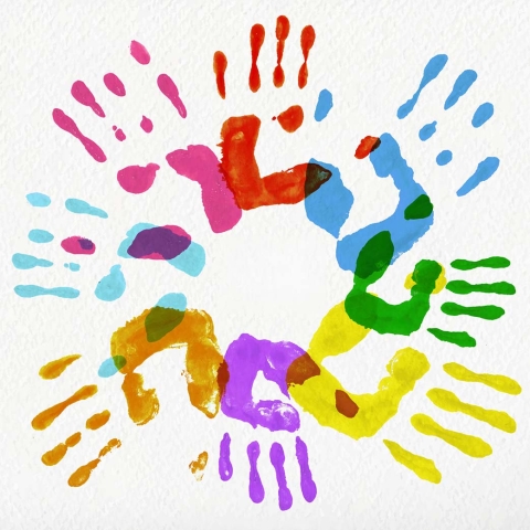 circle of brightly colored painted children's handprints