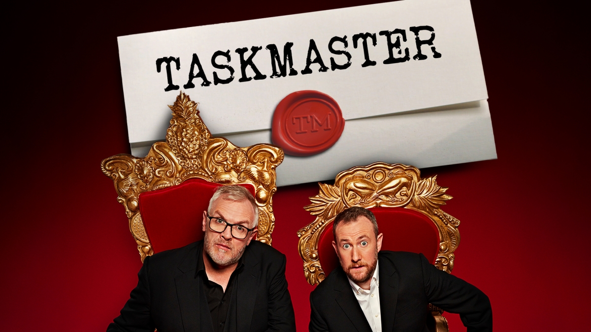 Hosts Greg Davies and Alex Horne with a paper letter with the Taskmaster logo